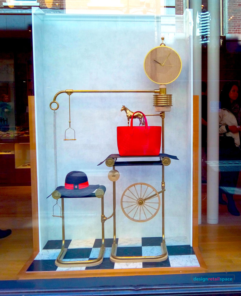 hermes window display presenting props related to horse riding and a horse statue