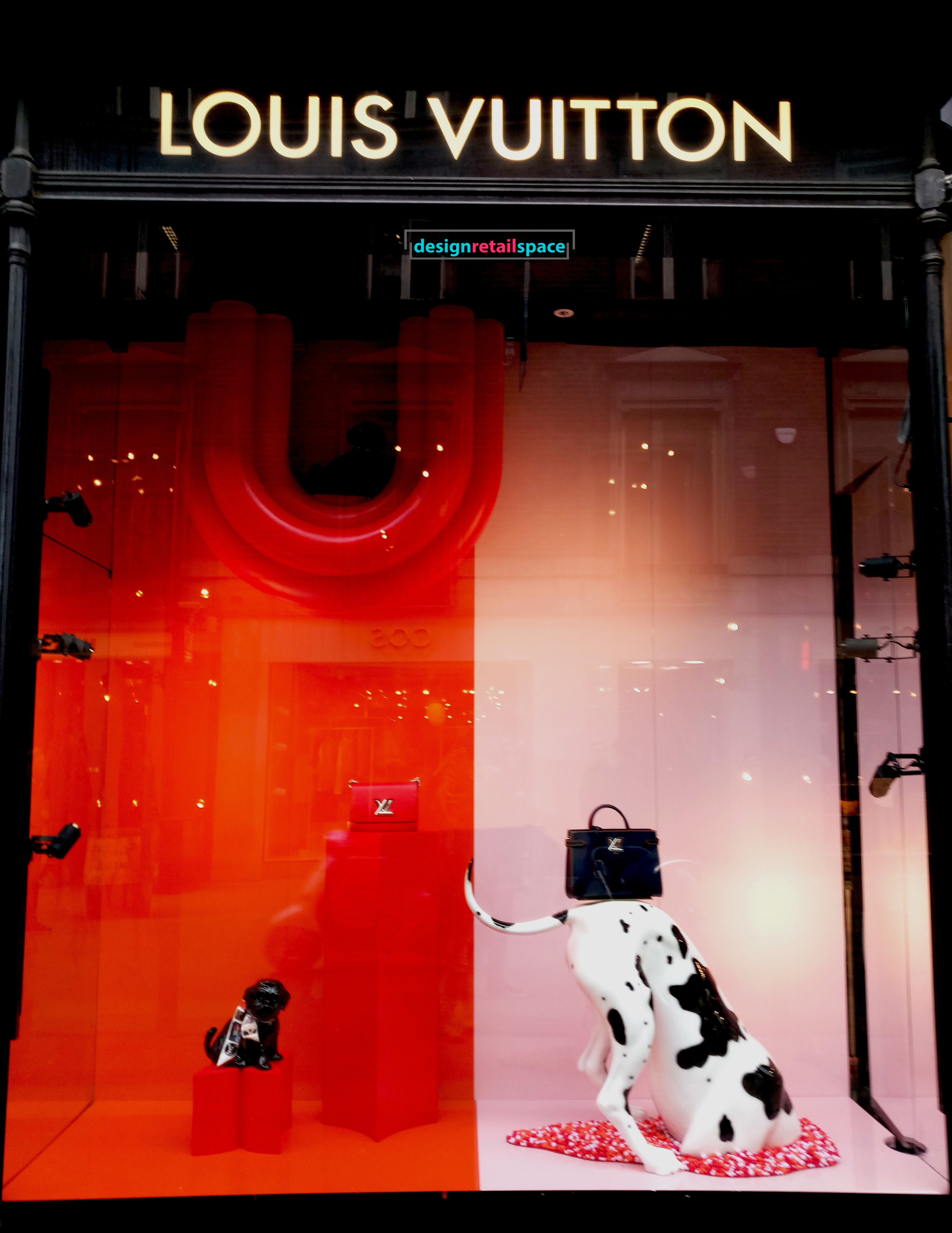 Louis Vuitton window display presenting Dalmatian digging against Millennial pink and red background