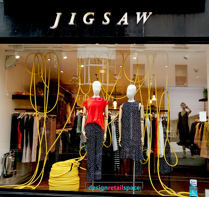 Jigsaw clothing shop with Gen Z yellow rope on the window display